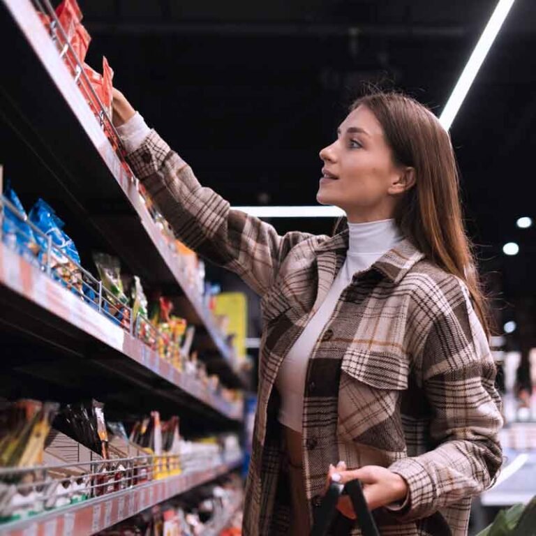 una chica se encuentra escogiendo algo de un estante de supermercado, analiza el comportamiento de tus consumidores